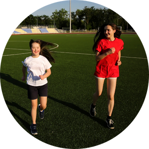 2 young ladies running on football field